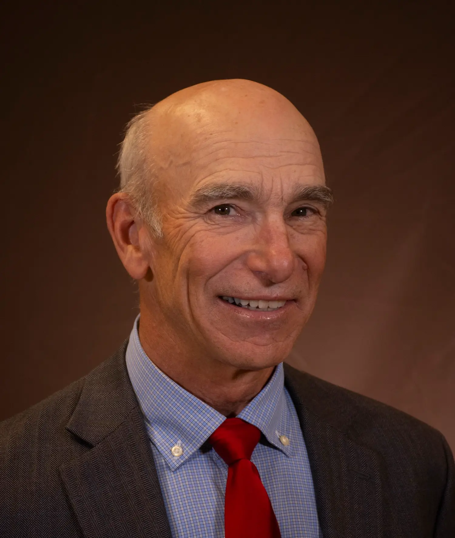 portrait of smiling man wearing collared shirt and tie with jacket