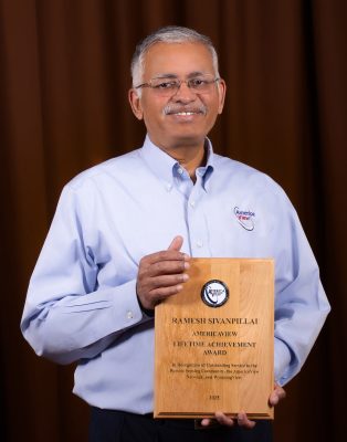 A man holding a plaque that reads "Ramesh Sivanpillai Americaview Lifetime Achievement Award - In Recognition of Outstanding Service to the Remote Sensing Community, the Americaview network, and WyomingView."