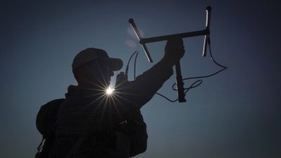 A silhouette of a man holding up a device
