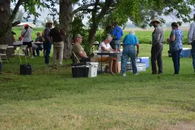 A group of people checking in at folding tables outside. 