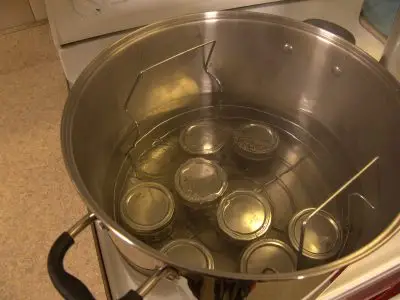 Several mason jars in a boiling water bath