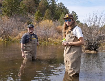 Two young men standing in a pool of water.