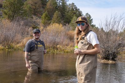 Two young men standing in a pool of water.