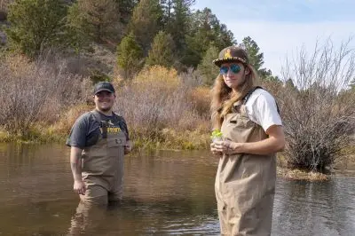 Two young men standing in a pool of water.