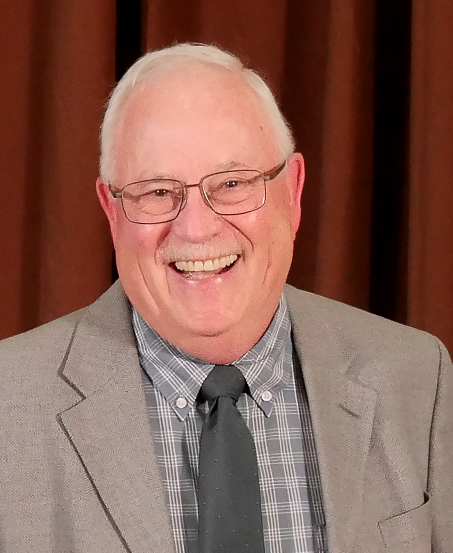 smiling man wearing suit jacket, collared shirt, and tie
