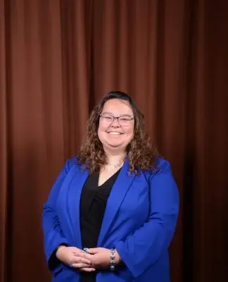 A young woman in a blue suit coat with a black shirt.