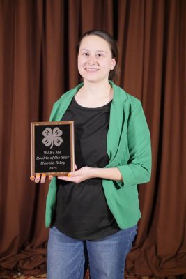A young woman holding a plaque.