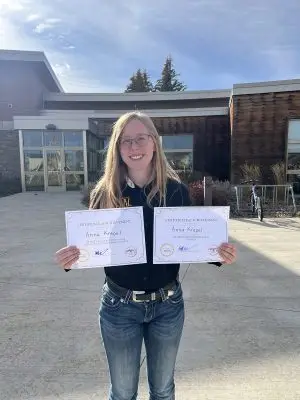 Anna Krepel holds two certificates of achievement, one for plant identification and one for an undergraduate range management exam contest.