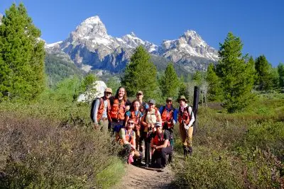 A group of people poses on a trail.