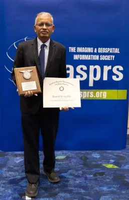 Ramesh Sivanpillai holds two plaques.