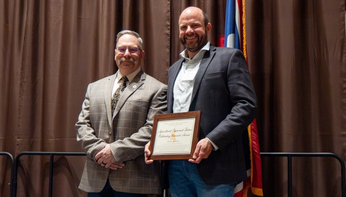 Jerod Merkle receives the Outstanding Research Award from Dean Kelly Crane.