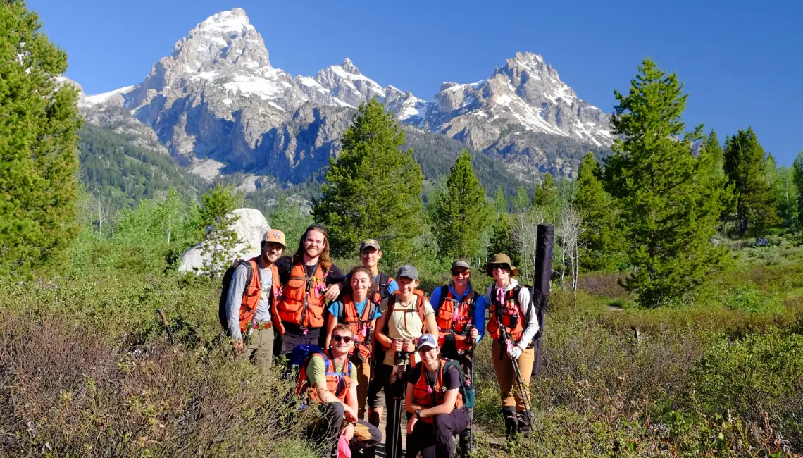 A group of people poses on a trail.