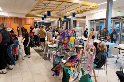 4-H youth display projects and engage visitors at booths during a busy indoor community event.