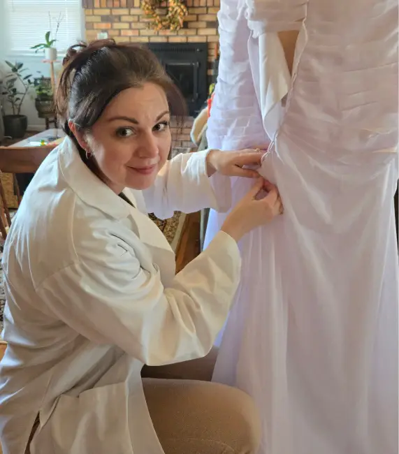 UW alumna Oksana Aycock, of Riverton, Wyo., performs alterations on a client’s wedding dress. She is the proprietor of two small businesses, Sunflower Alterations LLC and Sunflower Bride. Photo courtesy of Oksana Aycock.