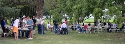 A group of people gather together outdoors for a meal.