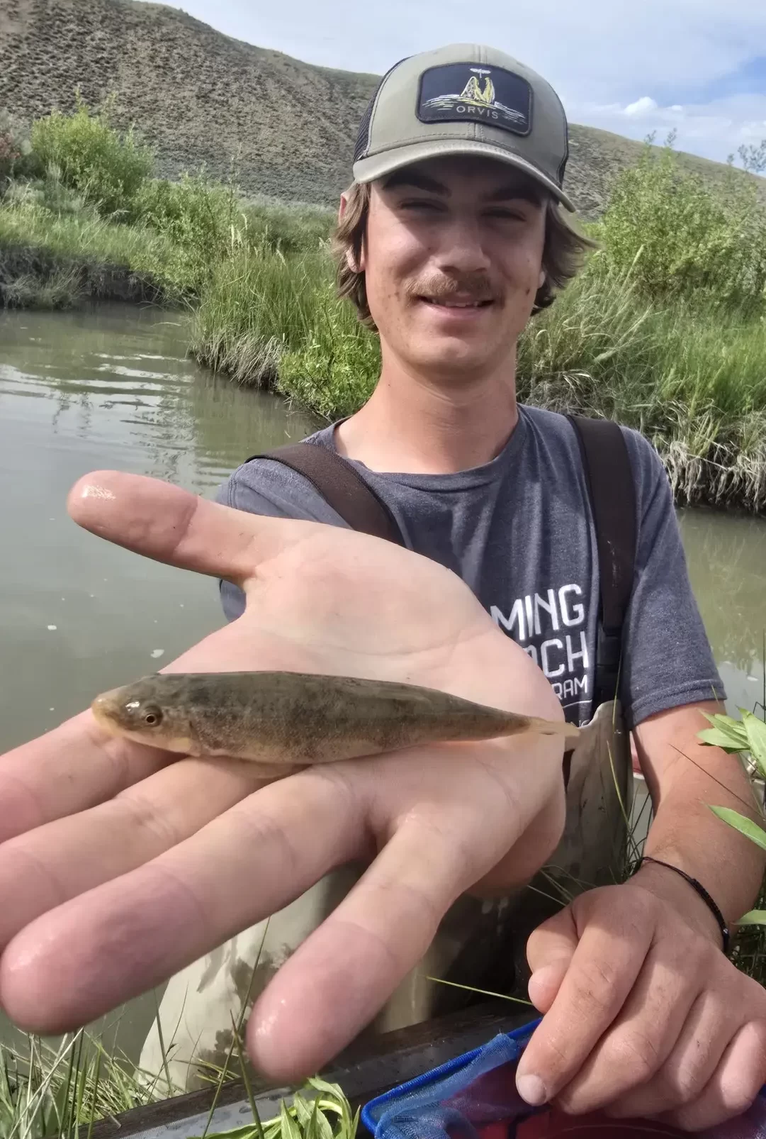 Miles Milbrath holds out a small fish.