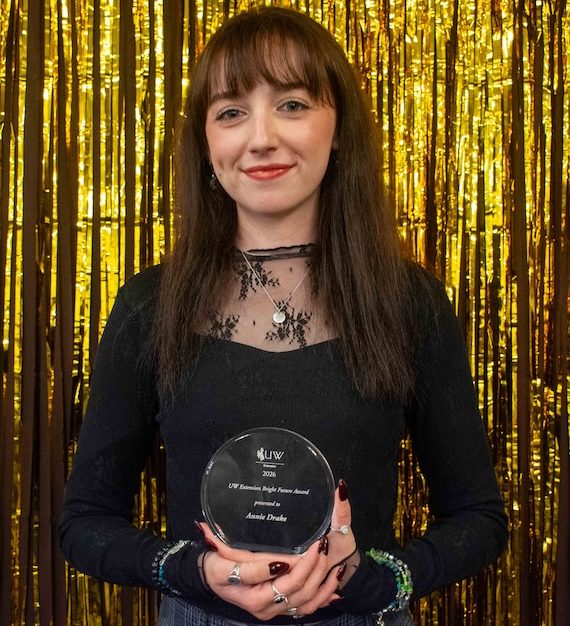 State office office associate Annie Drake holds an award.