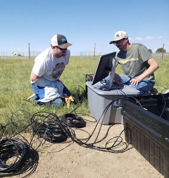 Daniel Reynolds and a colleague set up monitoring equipment to test wildlife-friendly fencing on sheep