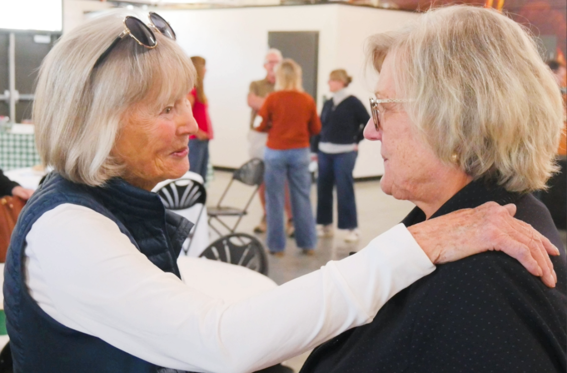 A woman embraces Mary Martin during her retirement celebration