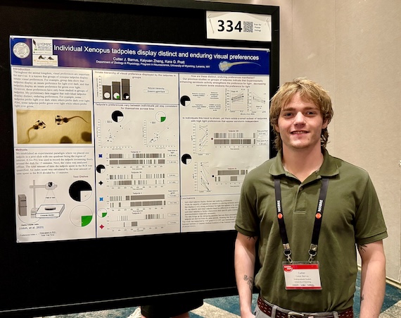 Cutter Barrus stands next to a research poster titled “Xenopus Tadpoles Display Distinct and Enduring Visual Preferences."