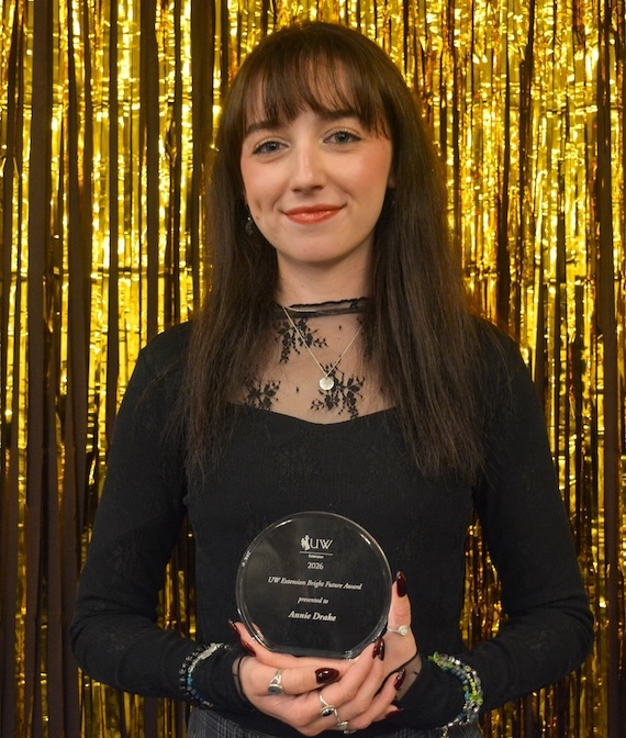State office office associate Annie Drake holds an award.