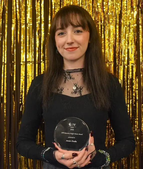 State office office associate Annie Drake holds an award.