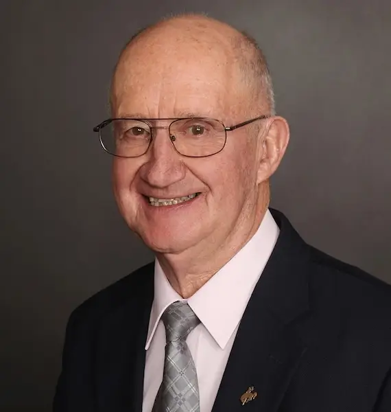 John Hines wearing glasses and formal attire